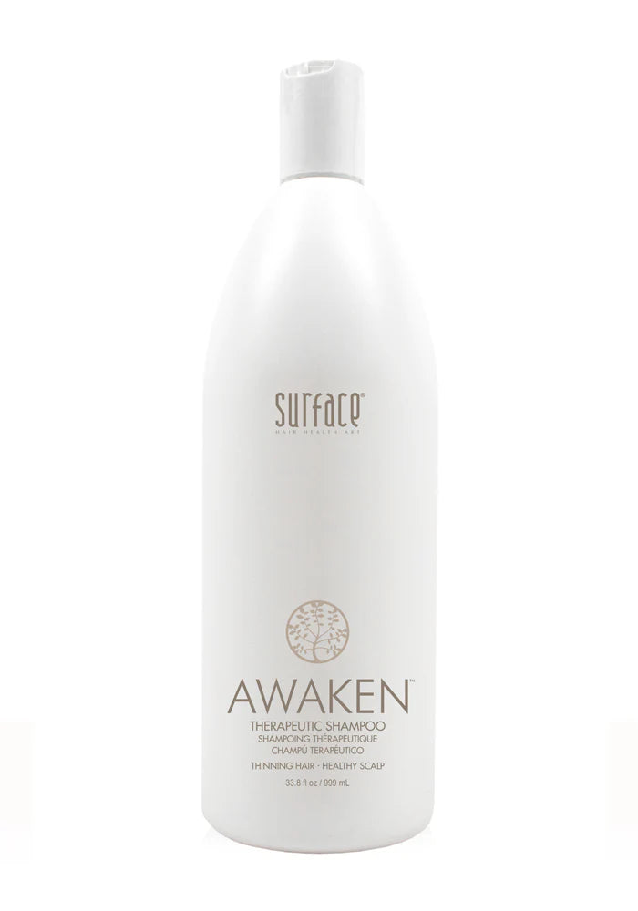 White shampoo bottle labeled 'Awaken' by 'Surface' on a white background